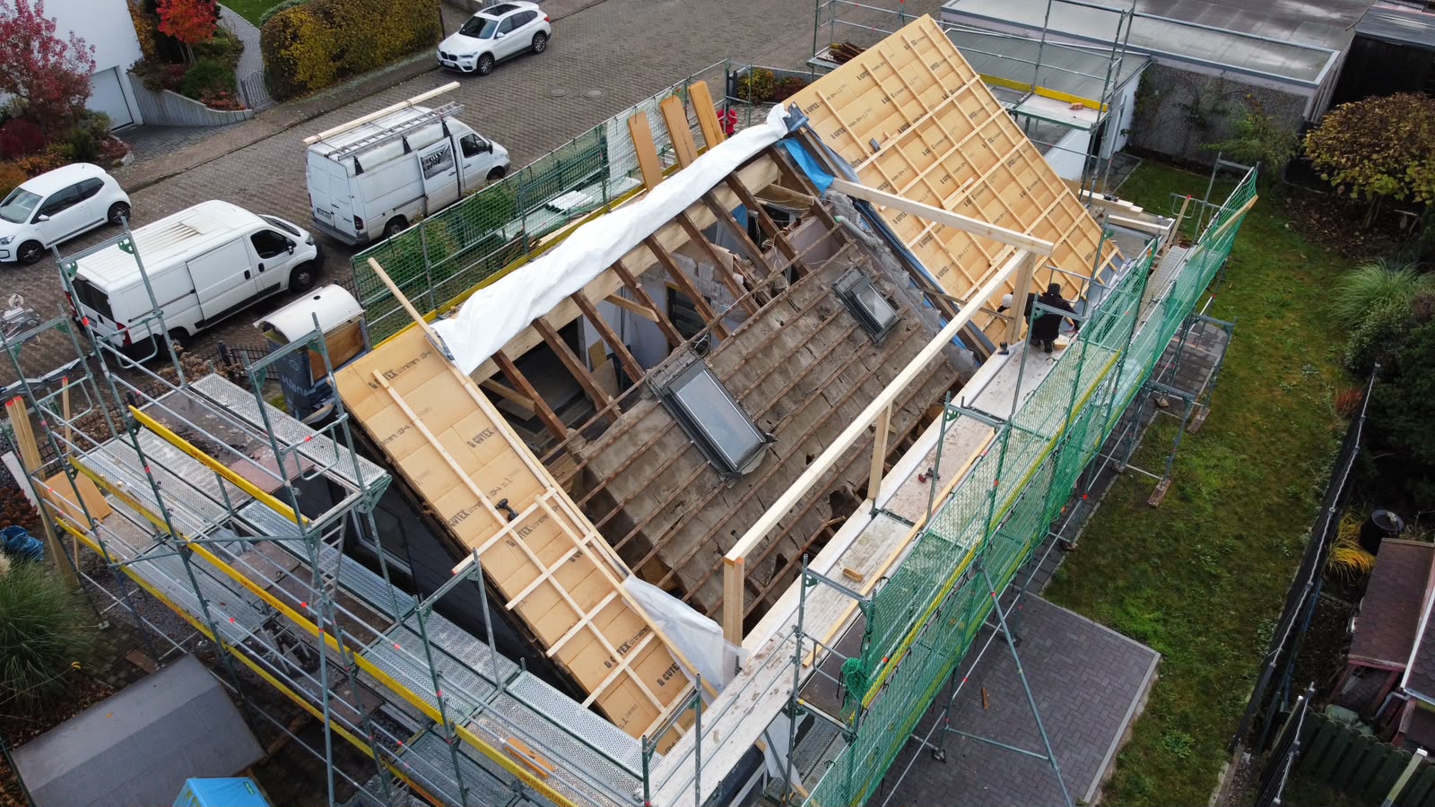 Freigelegter Dachbereich mit alten Dachfenstern und den ersten Holzbalken für die Unterkonstruktion der neuen Gaube